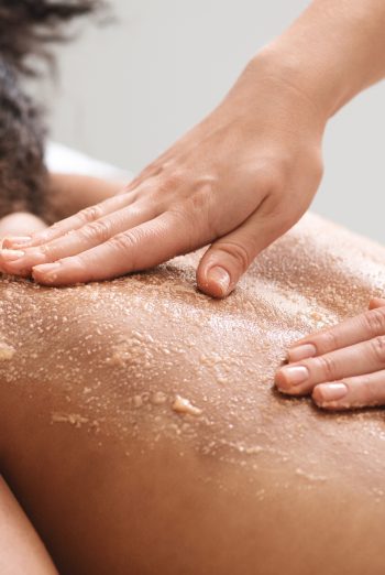 African american lady having skin scrubbing procedure at spa salon